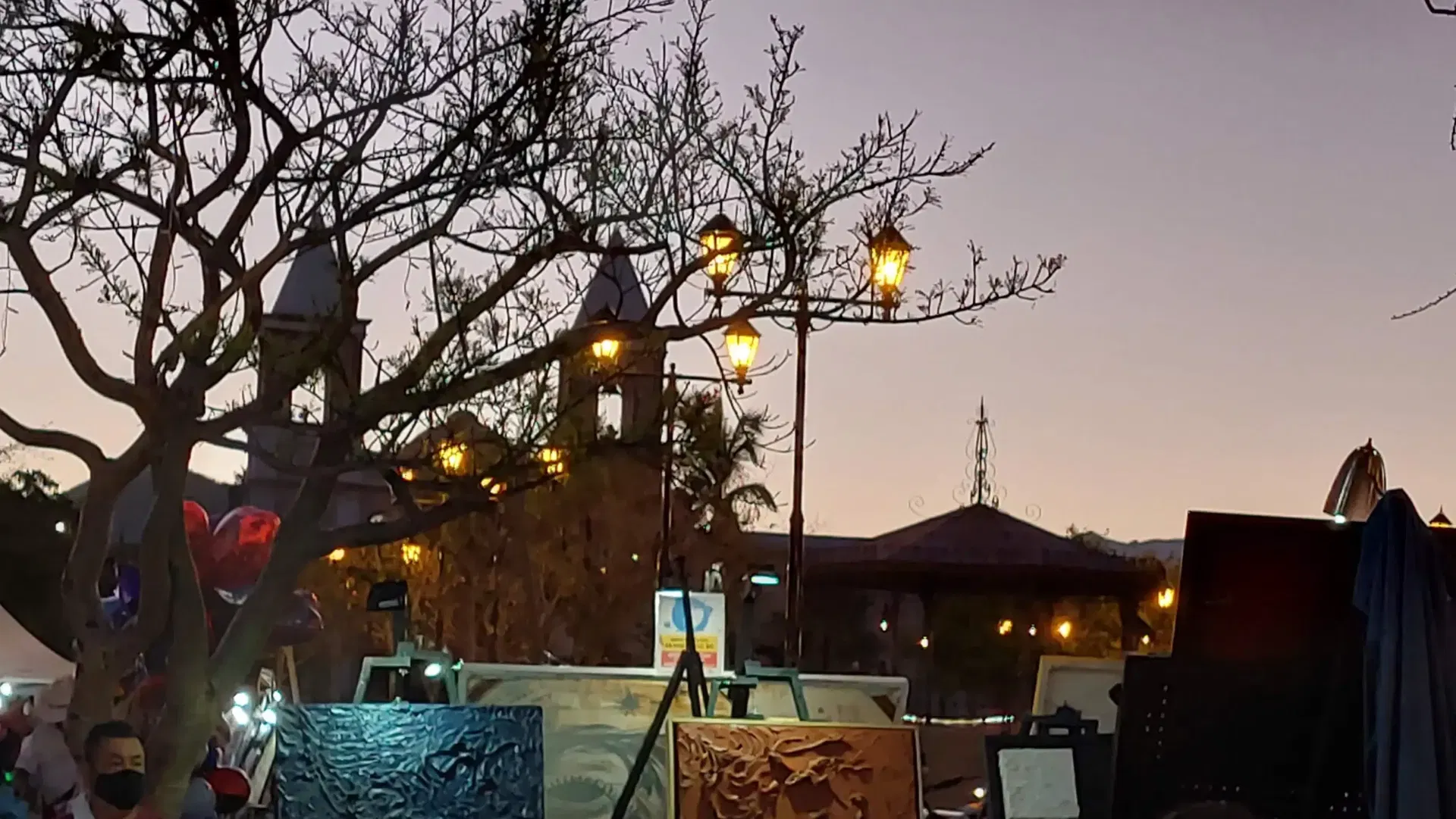 sunset at san jose del cabo downtown with the misión church at the background with paintings from artwalk events.